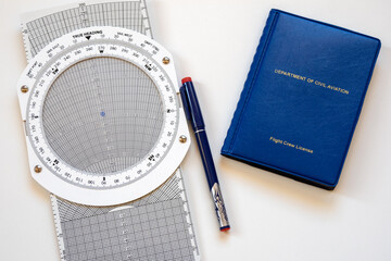 Flight navigation computer and pilot's license in a blue cover as an airline pilot training concept.