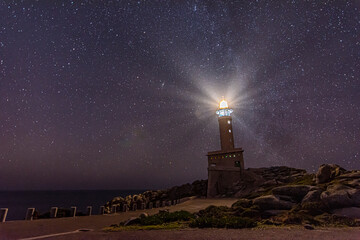 Panoramic view of Nariga lighthouse, in Malpica, under a starry winter night with many stars. High quality photo