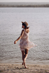 Summer travel vacation concept, Traveler woman with hat relax on beach at sunset