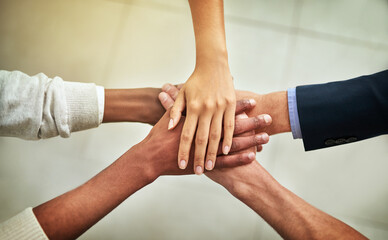 United in their business mission. Cropped shot of a group of businesspeople joining their hands in solidarity.