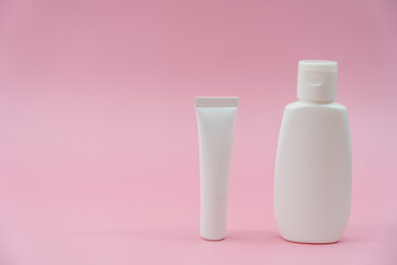 White plastic tubes on pink background. Сosmetic bottles for beauty or medicine products