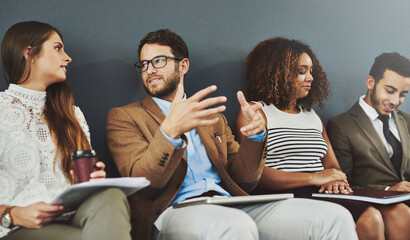 While we wait, lets have a chat. Studio shot of a group of businesspeople using wireless technology...