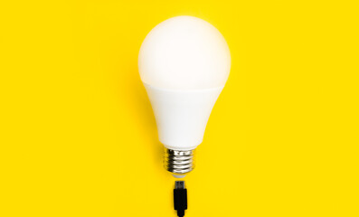 A glowing light bulb. Mockup. Empty space. Beautiful colors. Bright yellow background. Light bulb for advertising.