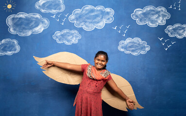 excited girl with wings flying on cloud doodle drawing on blue background - concept of childhood...