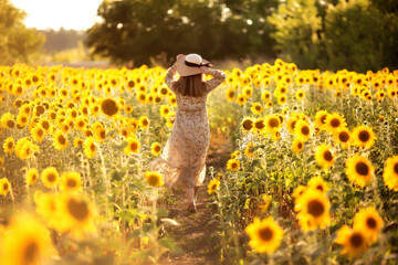 a girl in a hat in a field of sunflowers