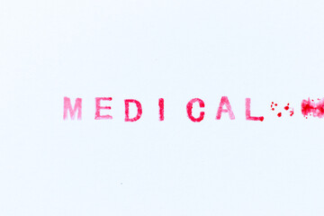 Red color ink rubber stamp in word medical on white paper background