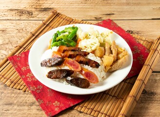 Hong Kong Style Lap Mee Rice with salad in white plate on mat isolated on wooden background top view chinese rice