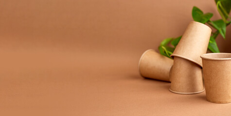 Zero waste. disposable paper cups with green leaves. Coffee and ecology. Beige background. Copy space