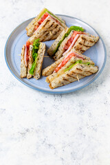 sandwich with ham cheese tomatoes lettuce onions on plate. Classic club sandwich with whole grain bread