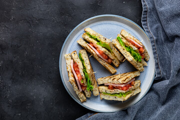 sandwich with ham cheese tomatoes lettuce onions on plate. Classic club sandwich with whole grain bread