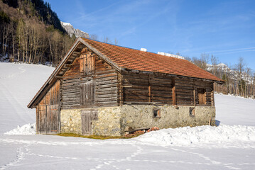 Old typical farmer's barn in the Alps during winter