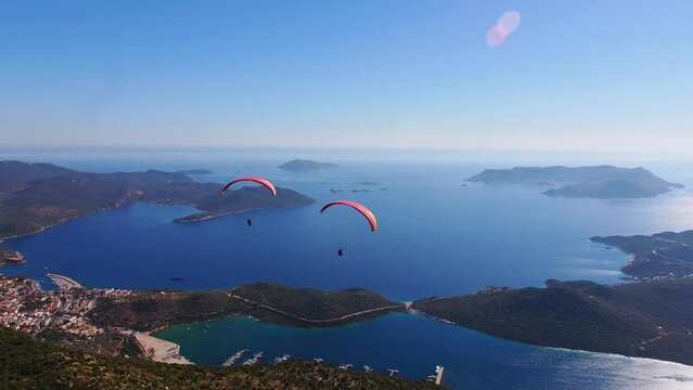 Aerial wide angle shoot of 2 tandem paragliders soaring above Antalya Kas Marina