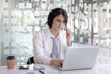 Businessman are greeting friends and manager through video chats and use headphones for communication and business conversations, Online communication, New normal, VDO Call, Internet learning.