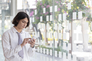 Finance workers are reviewing the company's financial data on a laptop and using smartphones to communicate or chat with the team during  social distances, Working alone in a private office.