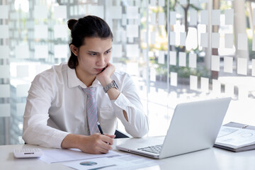 Fototapeta premium Head of marketing is recording the company's financial growth statistics using graphs as a reference for reviewing and analyzing the results, Taking notes and analyzing data graphs in office.