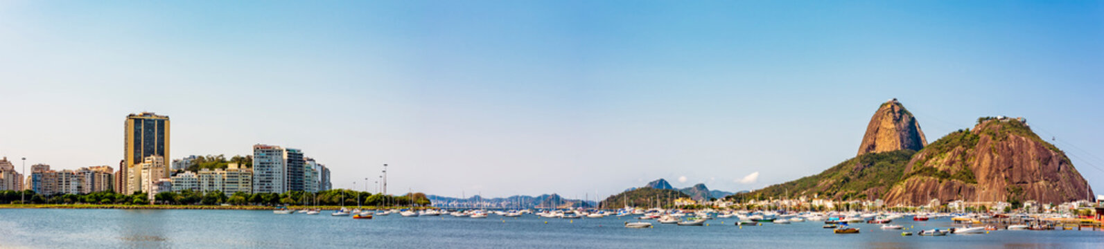Panoramic image of Rio de Janeiro with the boats moored, the Sugarloaf hill, Guanabara bay and Botofogo beach surrounded by the buildings and mountains of the city