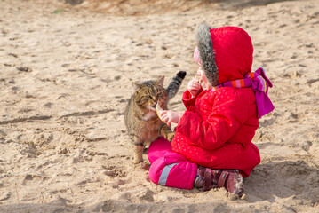 The child feeds the cat. Love for pets.
