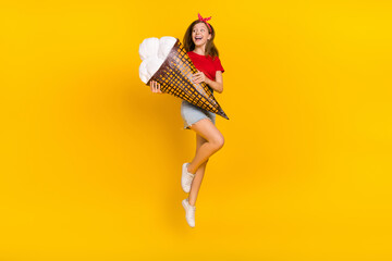 Full body photo of impressed teen girl jump with ice-cream wear t-shirt headband skirt sneakers isolated on yellow background