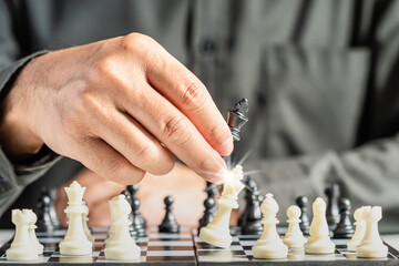 The hands of a business male business associate confident in strategy after playing chess to analyze and develop new planning. Concept of leadership and teamwork for victory and success in business.