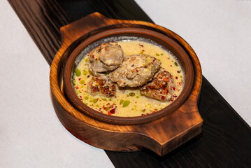 Veal in sauce. Food in a clay bowl. Eastern cuisine.