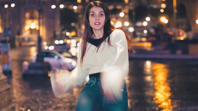 night dance - young woman performs modern dance steps on the street at night