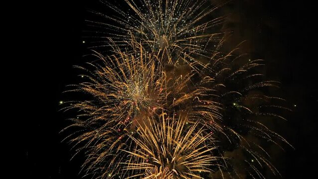 Slow motion: colorful fireworks in dark sky at night. Evening time, low light. Entertainment, holiday, abstract, celebrationand anniversary concept