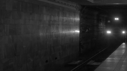 Black and white photo. Moving underground train. The arrival subway train at the station. City without traffic jams.