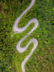 Aerial view of curve road on the mountain with green forest