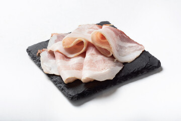 Bacon on a white background for insulation. bacon sliced thinly.Raw smoked bacon on a white background