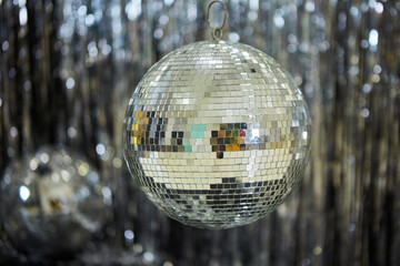 A large mirror ball on a shiny background. Reflective surface to create a lighting effect.