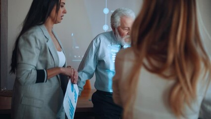 Elderly entrepreneur giving a presentation in a meeting and showing statistical graphs and diagram on a projector - Powered by Adobe
