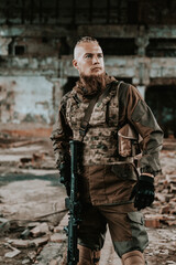 a male military soldier in an abandoned building with a gun poses, shoots and takes aim