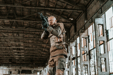 a male military soldier in an abandoned building with a gun poses, shoots and takes aim