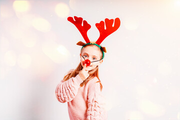 Little girl having fun wearing Christmas party glasses with reindeer antlers and red nose.Little...
