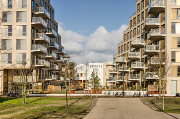 Amsterdam, The Netherlands, February 11, 2022: view from the park between residential buildings towards individual houses in Zeeburgereiland neighbourhood