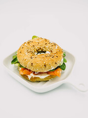 Bagel relleno de salmon ahumado, queso fresco y rucula