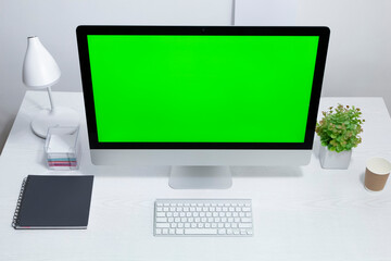Computer with green screen on desktop.