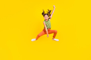Fototapeta na wymiar Photo of funky charming preteen girl dressed green top jumping high riding horse throwing lasso smiling isolated yellow color background