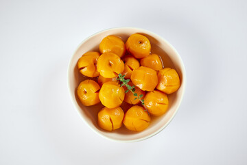 Homemade sweet peaches, a typical Ecuadorian dessert served on a traditional plate with a white background
