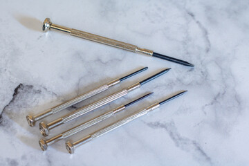 Different mini for delicate work on smallest screws in electronics and on marble background