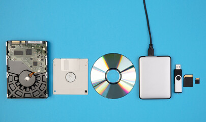 Data storage devices such as CDs, hard drives, pen drives and other, top view on a blue background...