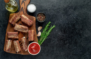 Fototapeta na wymiar grilled sliced ​​pork ribs on stone background with copy space for your text