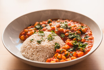 curry vegetarian chickpeas with vegetables. close up of fresh vegan indian curry, traditional meal of indian cuisine with coriander and basmati rice top view