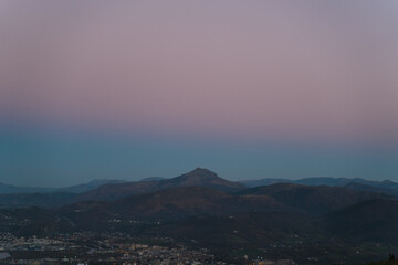 Blue and pink gradient sky over La Rhune mountain, natural border between France and Spain