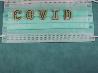 The word covid variant omicron in wooden letters on the face mask. High quality photo
