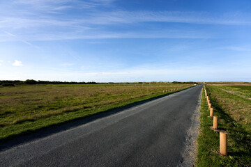 Empty road leading towards the beach. Blue sky for copy space. France Brittany.