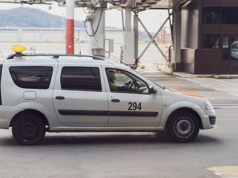 Russia, Sochi 02.11.2021. A white official car with a man in uniform at the wheel drives through the airfield. Airport Service