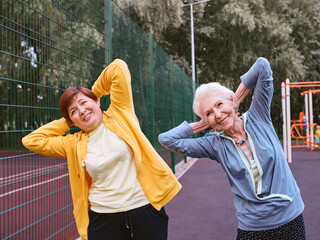 Obraz premium two mature women doing sport exercises in the park. healthy lifestyle concept