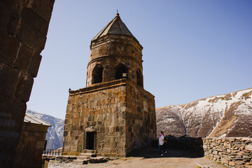 A beautiful mountain landscape with a blue sky and a church. Snow-capped peak of Mount Kazbek in Stepantsminda Georgia