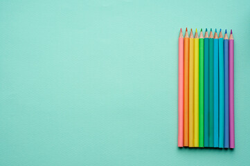 colored pencils for children on a plain light blue background, space for text, top view, stationery, Flat lay, flatly, lay out, school supplies